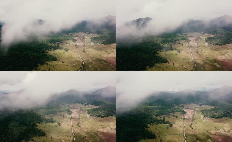 航拍云雾缠绕高山森林草甸谷地