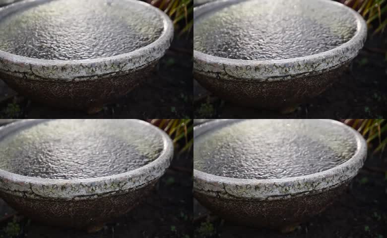 老旧石盆内水面泛起细密涟漪