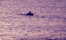 黄昏水面上单人划小船