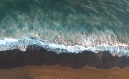 白浪冲刷黑色沙滩