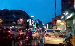 傍晚雨后湿漉漉城市商业街车流